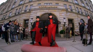 Zwei Pagen des Hotels Adlon rollen den roten Teppich vor dem Hotel Adlon in Berlin aus (Bild: IMAGO / PEMAX)