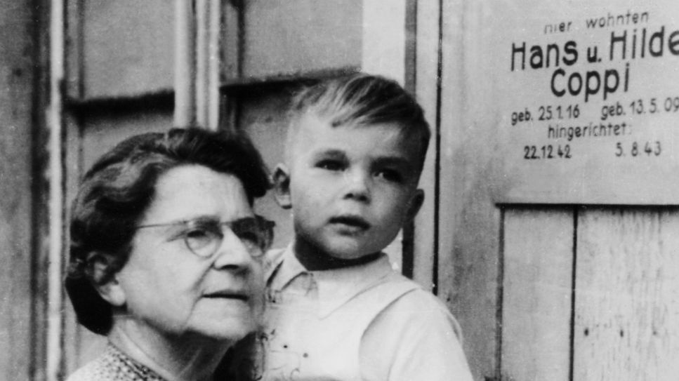 Hans Coppi junior in den Armen seiner Großmutter neben Haus-Gedenktafel "Hier wohnten Hans und Hilde Coppi" (Bild: HR/Privatfoto)
