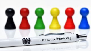 Spielfiguren in den Farben der größten deutschen Parteien und Kugelschreiber des Deutschen Bundestages, Symbolfoto Bundestagswahl (Bild: picture alliance / CHROMORANGE | Christian Ohde)