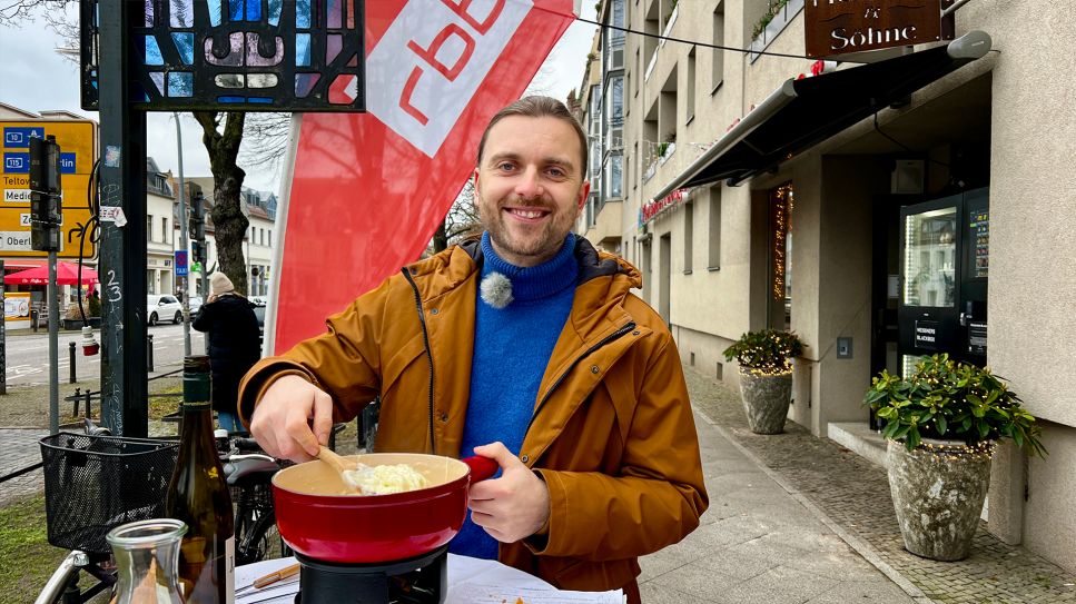 Andreas Jacob testet ein Käsefondue vor dem Laden "Chez Martin" in Potsdam-Babelsberg (Bild: rbb/ Silke Cölln)