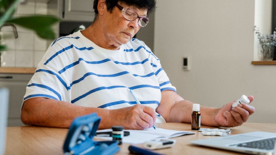 Frau am Laptop, vor sich Medikamente (Quelle: imago images/Westend61)