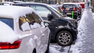 Ein Kleinwagen vom Typ Smart hat eine winzige Parklücke zum Parken quergestellt genutzt (Quelle: IMAGO/Jochen Tack)