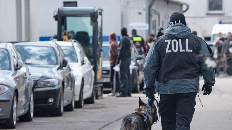 Symbolbild: Ein Hundeführer vom Zoll geht am 14.04.2021 über ein Gelände in Berlin-Lichtenberg. (Quelle: dpa-Zentralbild/Paul Zinken)