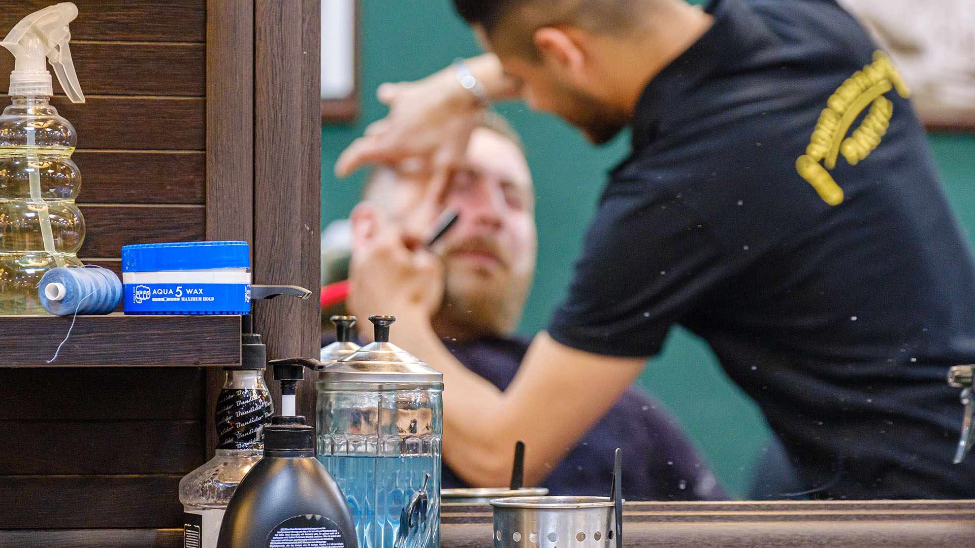 Symbolbild: Einem Kunden wird in einem Barber-Shop der Bart gekürzt. (Quelle: imago images/Wojtyczka)