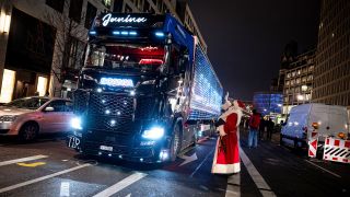 Eine Person als Weihnachtsmann begrüßt bei einer Aktion des Bezirksamts Charlottenburg-Wilmersdorf einen "Weihnachtstruck" am Breitscheidplatz. (Quelle: dpa/Fabian Sommer)