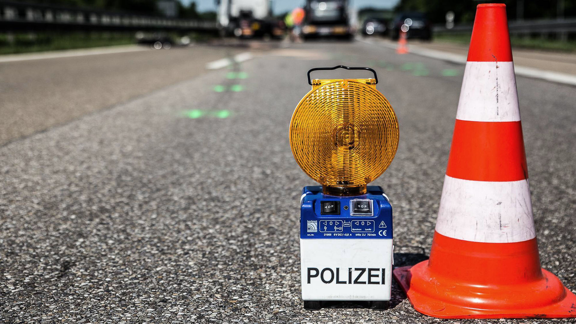 Symbolbild:Ein Signallicht und ein Kegel der Polizei stehen bei einer Absperrung wegen eines Unfalls auf der Fahrbahn.(Quelle:imago images/onw-images)