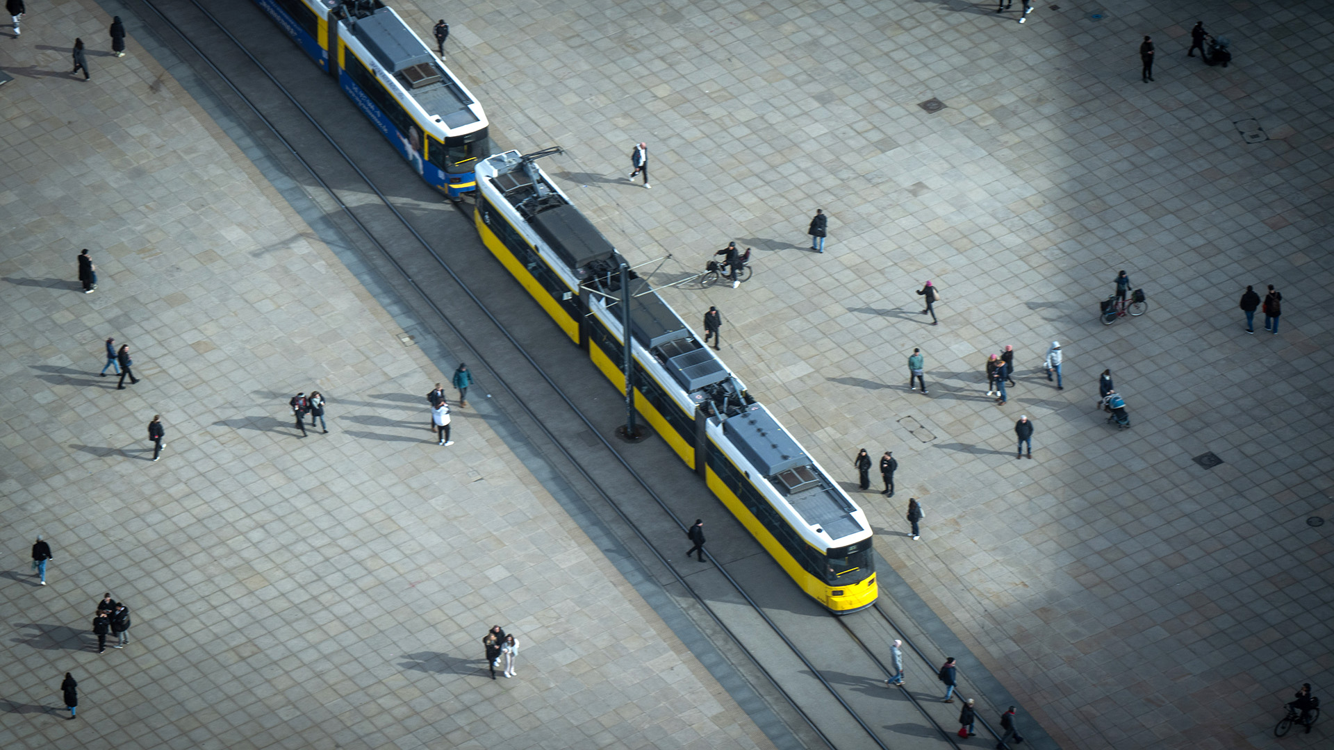 Zahlreiche Menschen gehen am 23.02.2024 über den Alexanderplatz, während eine Straßenbahn der BVG über den Platz fährt; aufgenommen vom Fernsehturm bei einer Pressekonferenz zur Vorstellung der Tourismus-Bilanz des Amts für Statistik Berlin-Brandenburg (Quelle: dpa / Monika Skolimowska)..